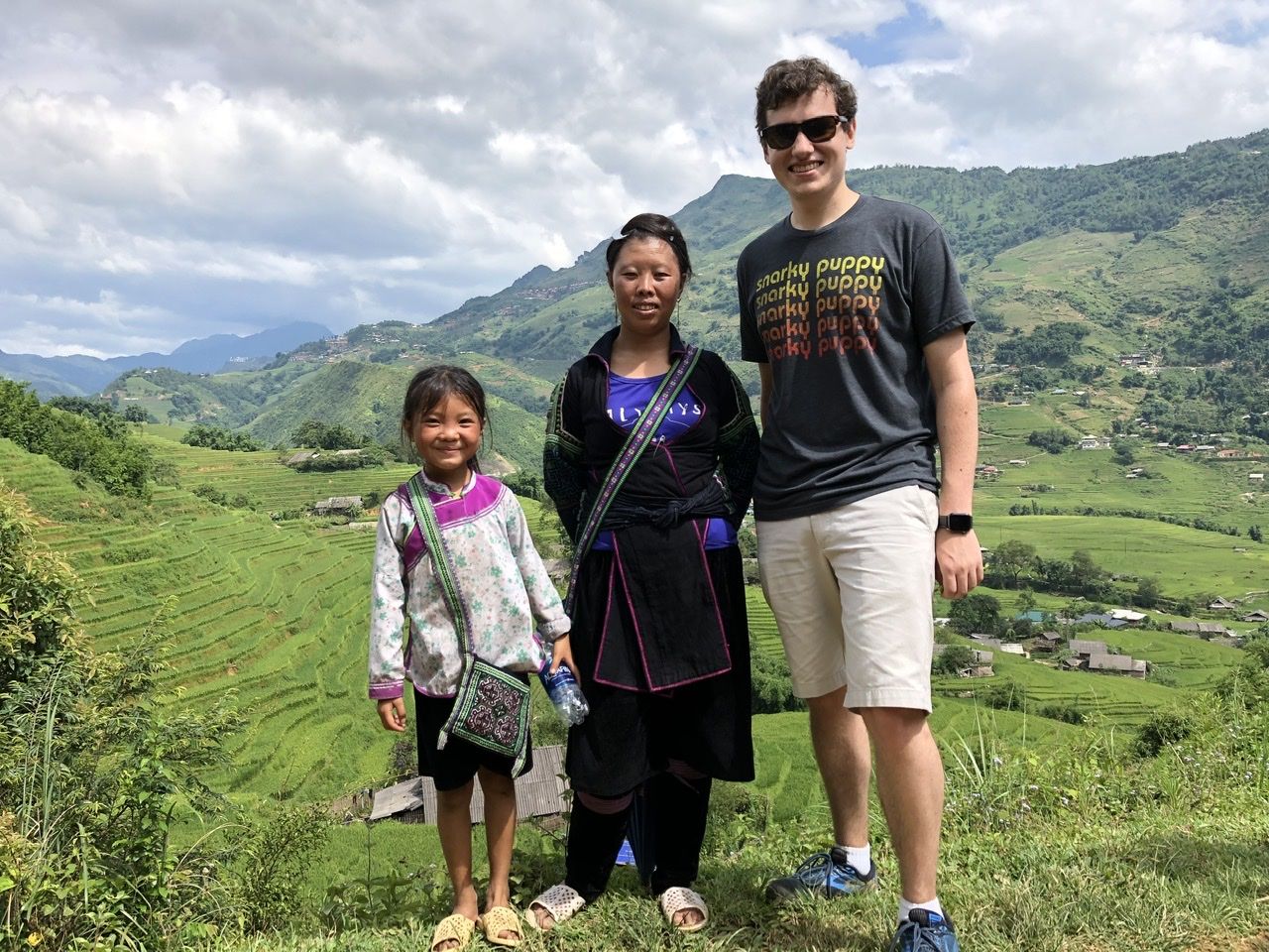Standing with a Hmong woman and child